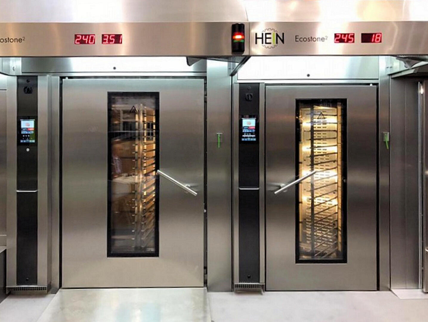 Zwei große Industrieöfen aus Edelstahl mit Glastüren und Digitalanzeigen zeigen Temperaturen von 240°C und 245°C an. Die Backbleche sind im Inneren der Öfen sichtbar. Die Marke HEN ist oben abgebildet.
