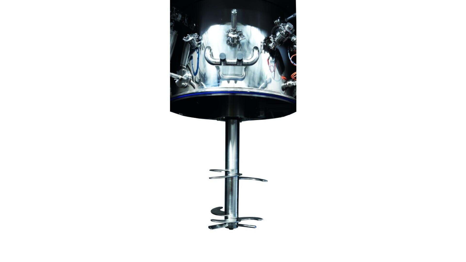 Nahaufnahme des unteren Teils eines industriellen Mischbehälters aus rostfreiem Stahl mit der angebrachten Mischerwelle und den nach unten gerichteten Laufradschaufeln.