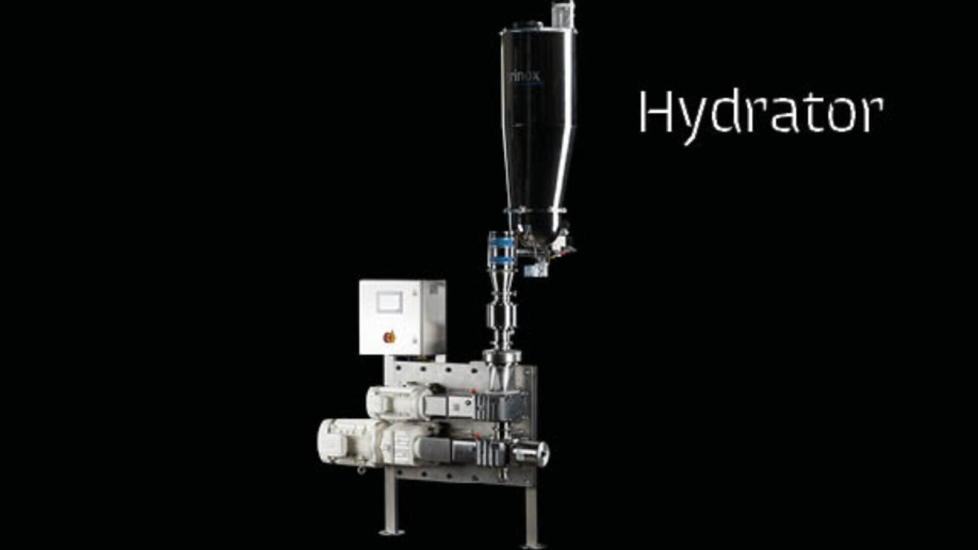 A metal industrial machine labeled Hydrator stands against a black background, featuring a tall cylindrical tank, control box, motors, pipes, and support legs.