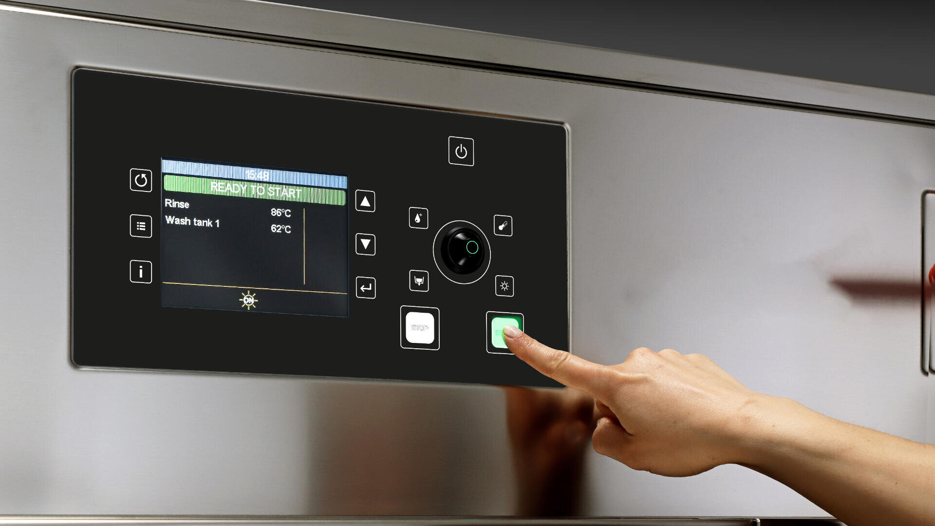 A person presses the green start button on the control panel of a stainless steel industrial dishwasher, with a digital display showing rinse and wash tank temperatures.