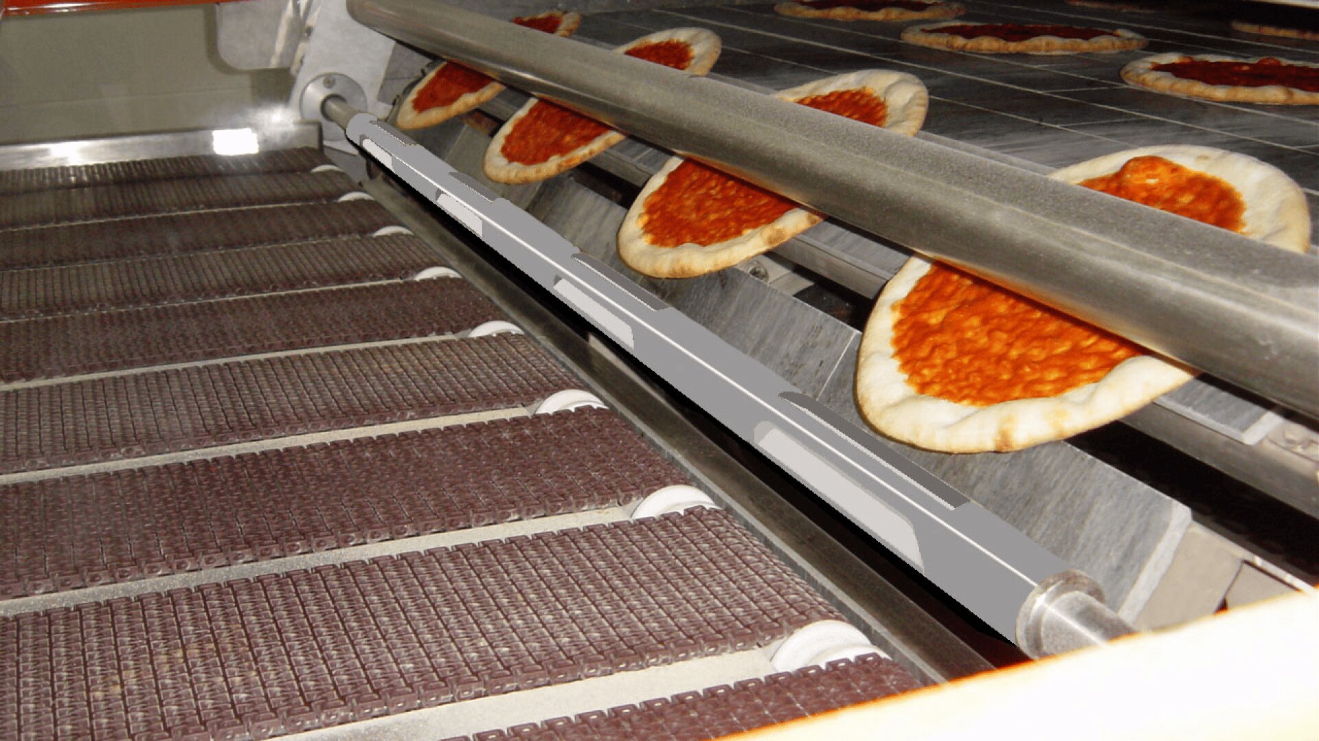 A food production line with pizza crusts topped with tomato sauce moving along a conveyor belt, preparing for the next stage of processing.