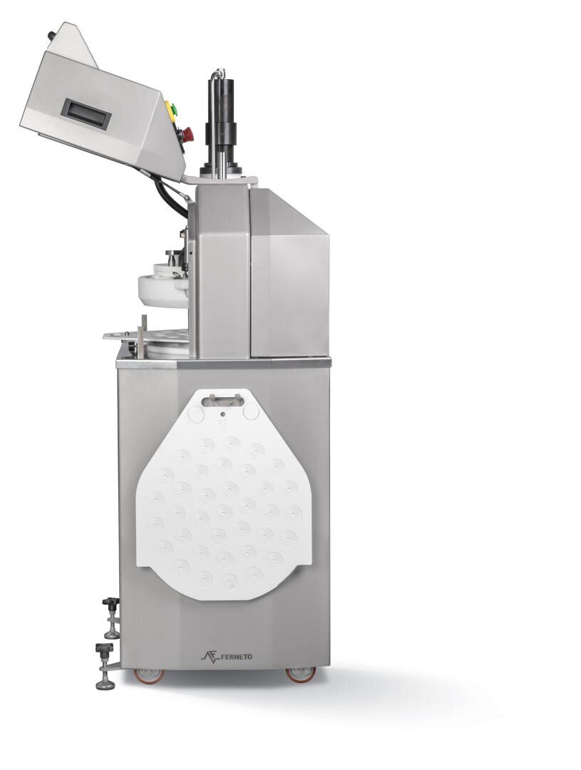 A stainless steel industrial food processing machine with an open top lid, various control buttons, and a white panel attached to the front, standing on wheels.