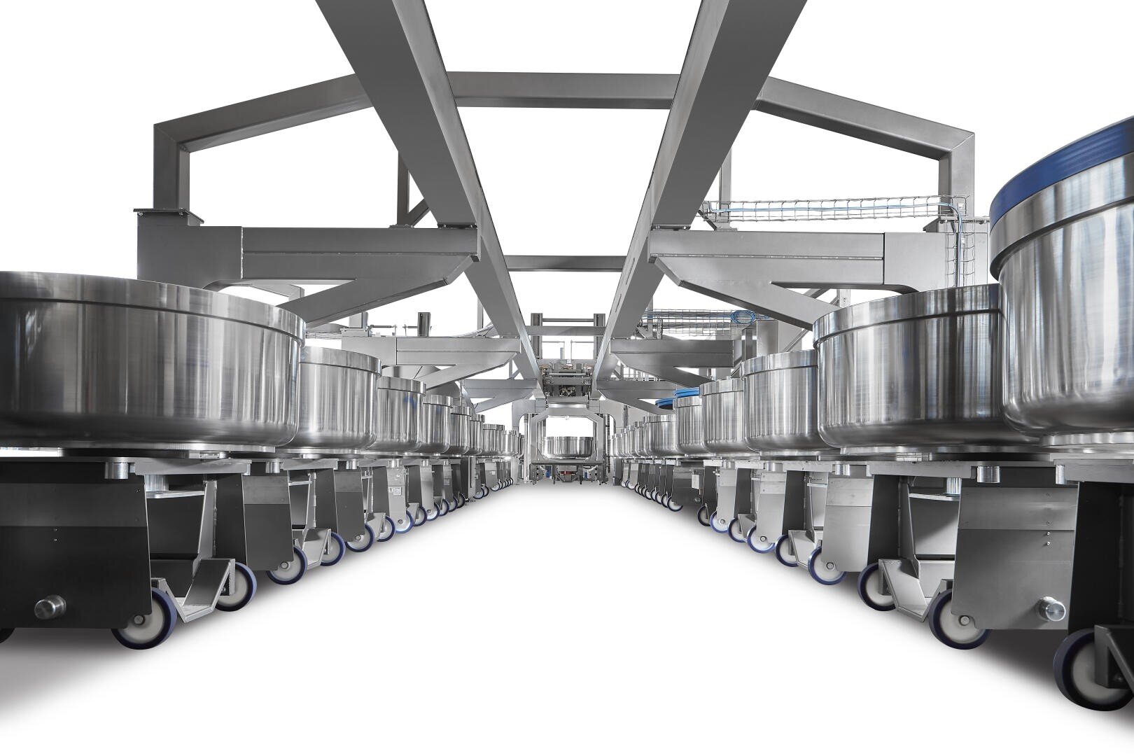Industrial kitchen equipment: rows of large stainless steel containers on wheels are aligned under a framework, creating a symmetrical, high-tech food processing environment with a clean, bright setting.