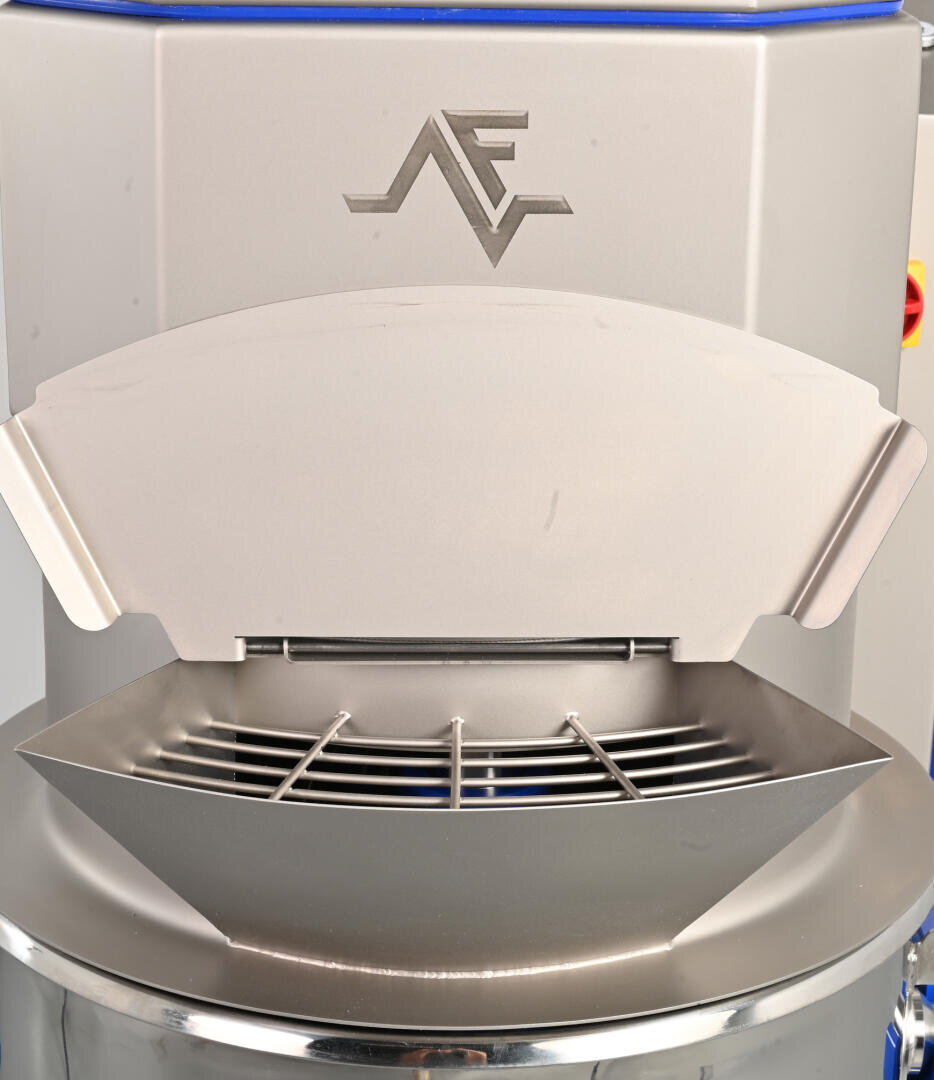 Close-up of a metallic industrial machine with a logo featuring the letters AF on the front, a curved shield-like plate, and a grated opening below. The machine has a modern, clean design.