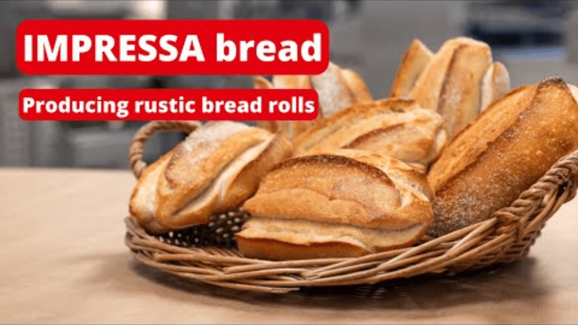 A wicker basket filled with rustic bread rolls sits on a countertop. Text reads IMPRESSA bread and Producing rustic bread rolls in bold red and white boxes.