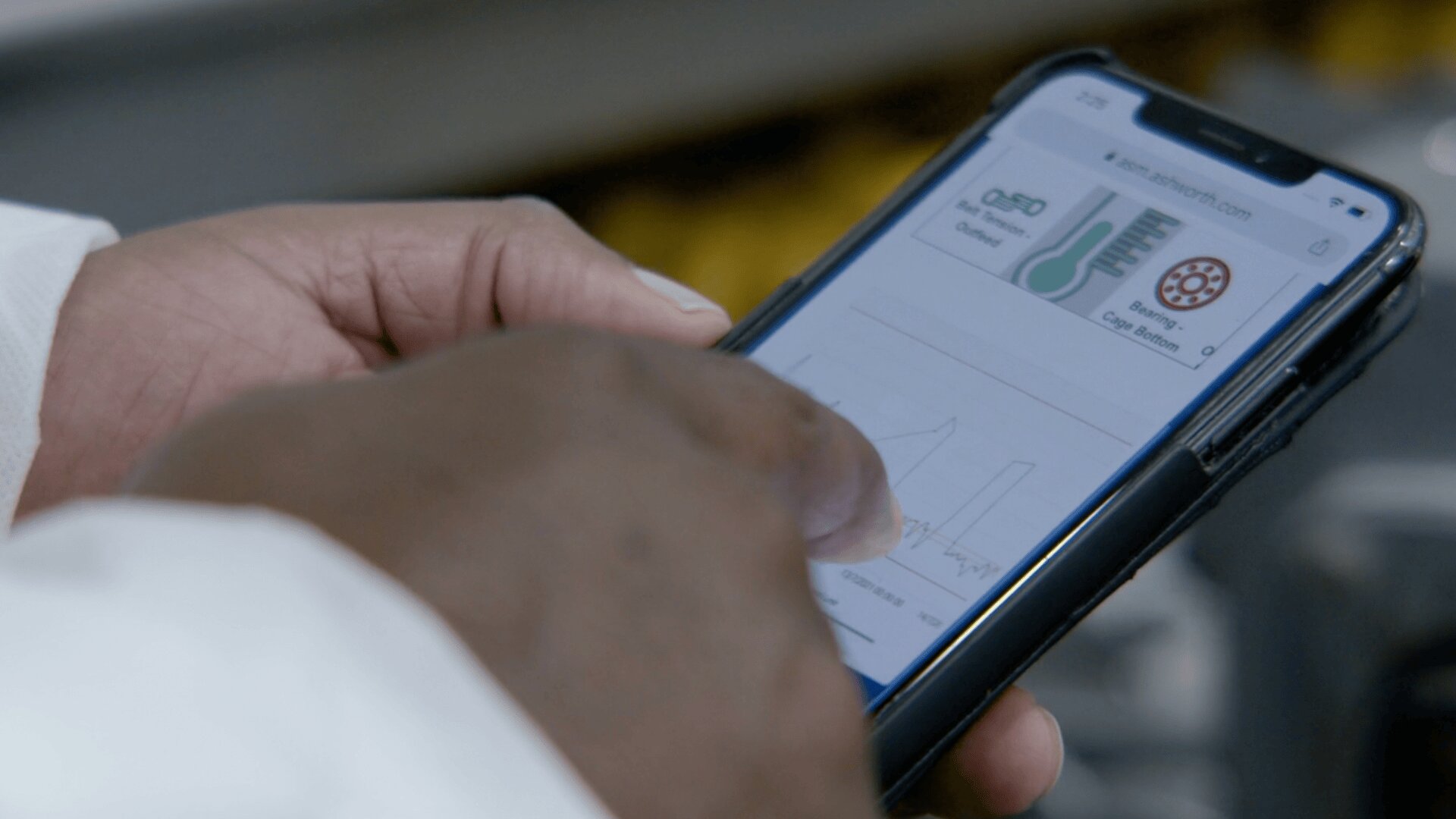 A person uses their finger to interact with a smartphone displaying a graph and icons on a website, viewed up close.