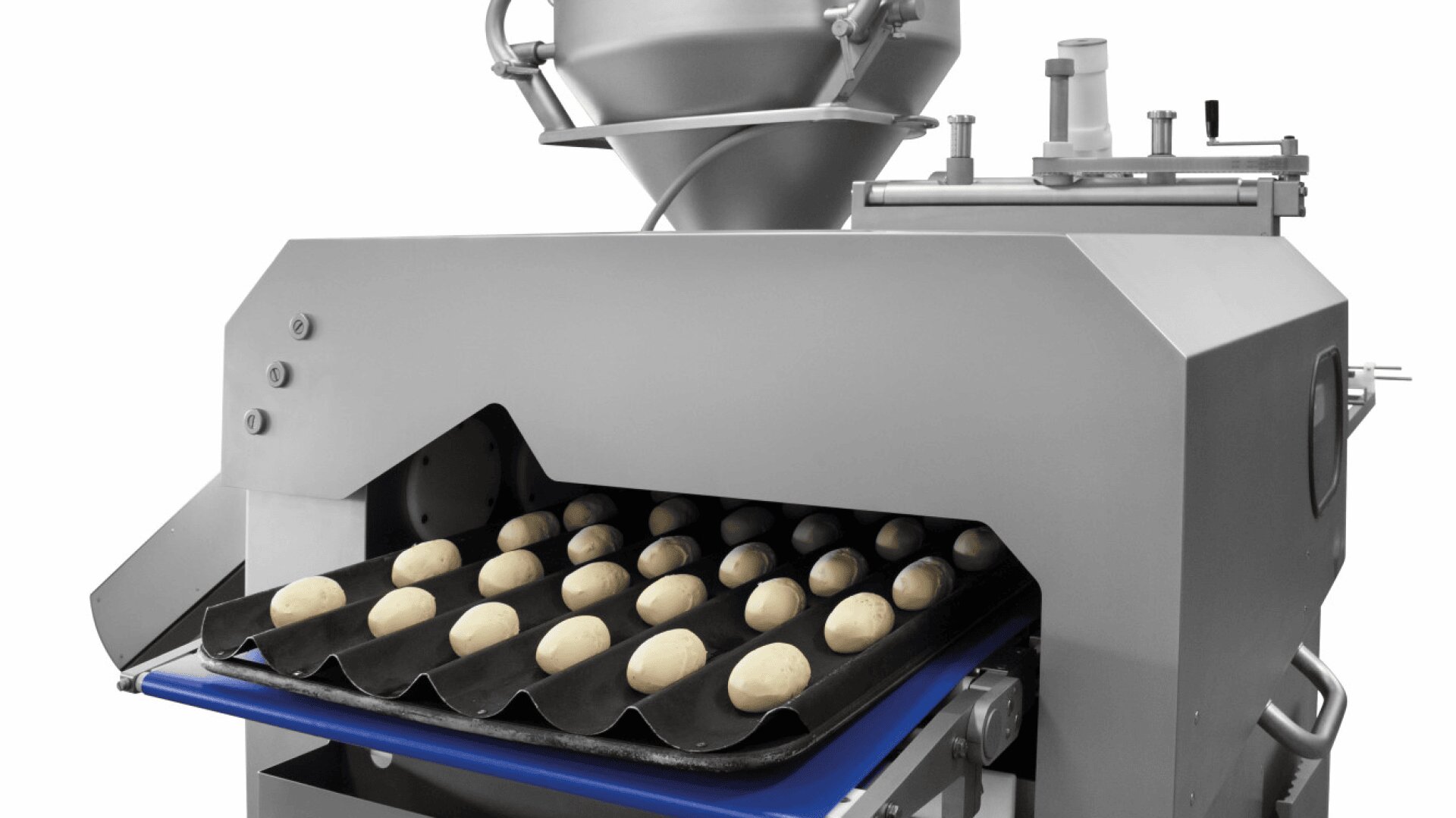 Eine Lebensmittelverarbeitungsmaschine legt gleichmäßige Teigkugeln auf ein schwarzes Tablett mit flachen Rillen und bereitet sie zum Backen oder zur Weiterverarbeitung vor. Das Gerät ist aus rostfreiem Stahl und industrietauglich.