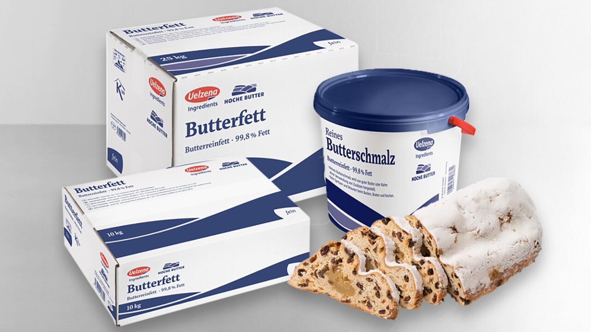 Boxes and a tub of Jelena brand Butterfett and Butterschmalz are displayed alongside several slices of stollen, a traditional German fruit bread dusted with powdered sugar.