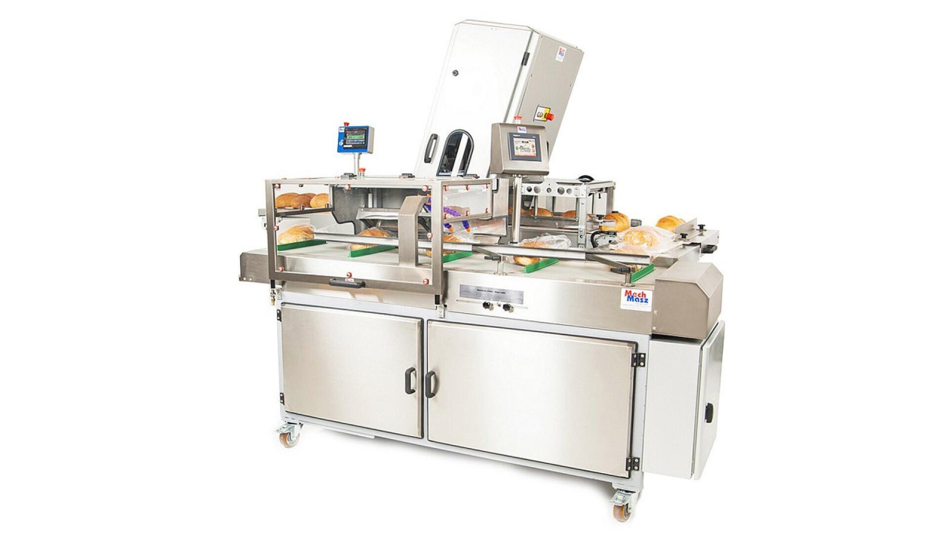 A commercial bread slicing machine with loaves of bread on the conveyor, transparent safety cover, digital control panels, and stainless steel body on wheels.