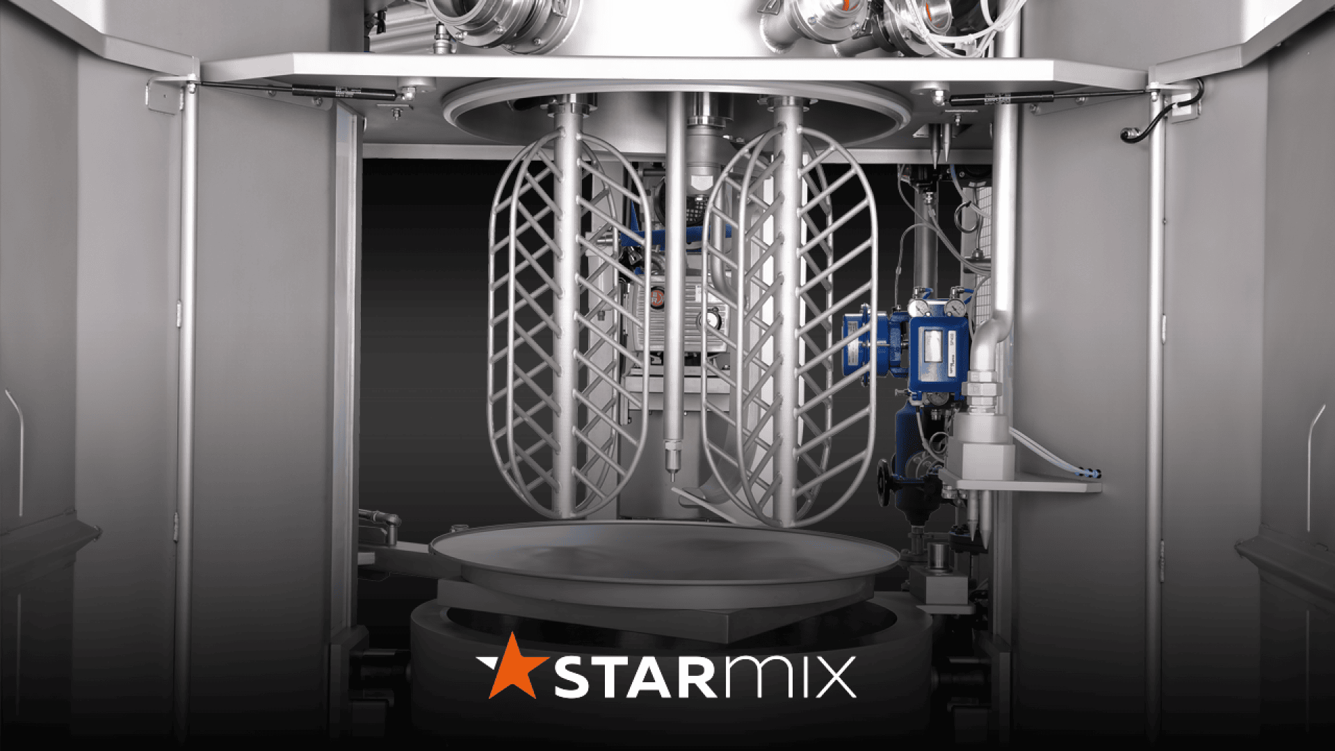 Industrielle Mischmaschine mit zwei großen Spiralschlägern in einer Metallkammer. Verschiedene mechanische Komponenten und Bedienelemente sind sichtbar. Das Wort STARMIX mit einem Stern-Logo ist unten abgebildet.