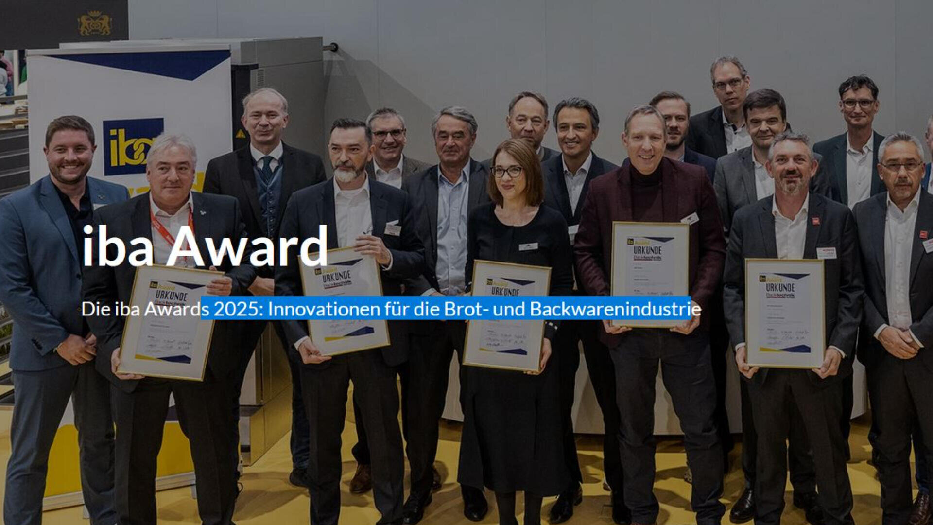 Eine Gruppe von Menschen in Geschäftskleidung steht in einem Innenraum, einige halten gerahmte Urkunden. Der Text lautet: iba Award und Die iba Awards 2025: Innovationen für die Brot- und Backwarenindustrie.