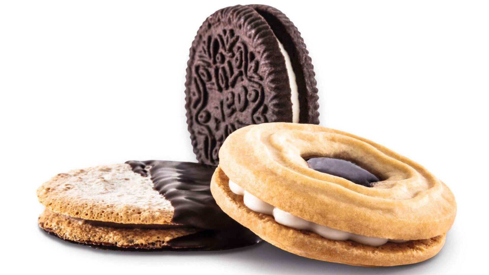 Three assorted cookies: a chocolate sandwich cookie, a round cookie with white filling and a dark center, and a half-chocolate-dipped cookie, all arranged on a white background.