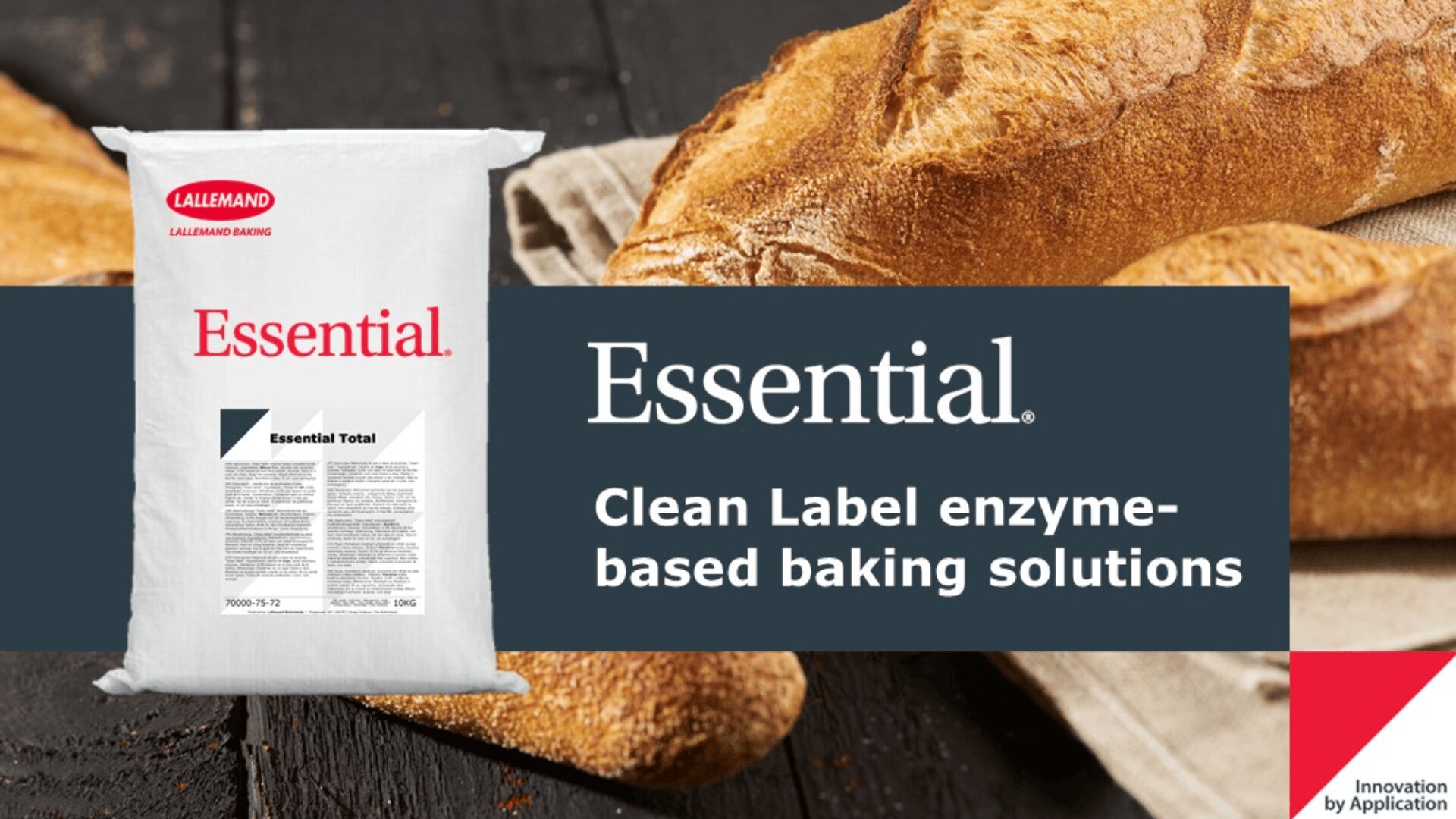 A bag labeled Essential sits next to loaves of bread on a wooden surface. Text reads Essential. Clean Label enzyme-based baking solutions. A red and white logo in the corner says Innovation by Application.