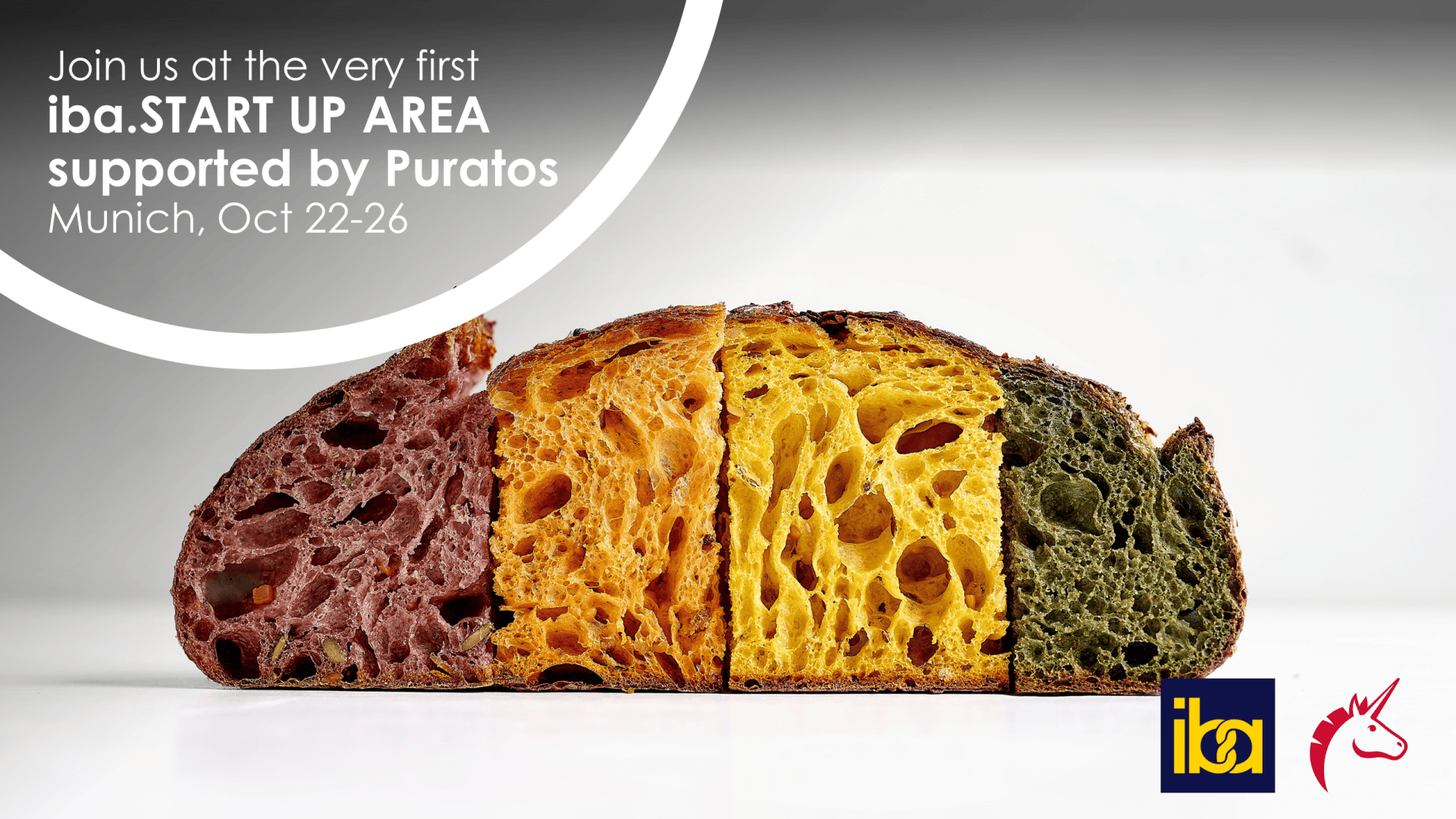 Four slices of artisan bread in red, brown, yellow, and green are shown in a row. Text invites viewers to the iba.START UP AREA in Munich, Oct 22-26, supported by Puratos. iba and unicorn logos are visible.