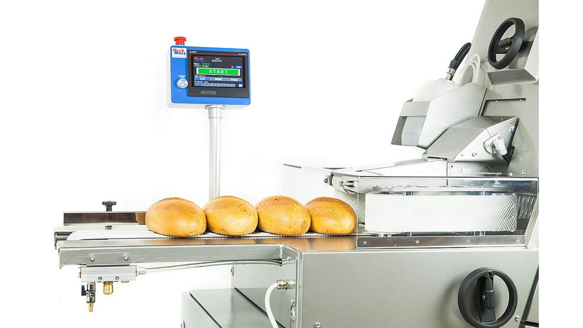 Four loaves of bread move along a conveyor belt towards a slicing machine, with a digital control panel displaying information above the equipment. The background is white and the setting appears industrial.