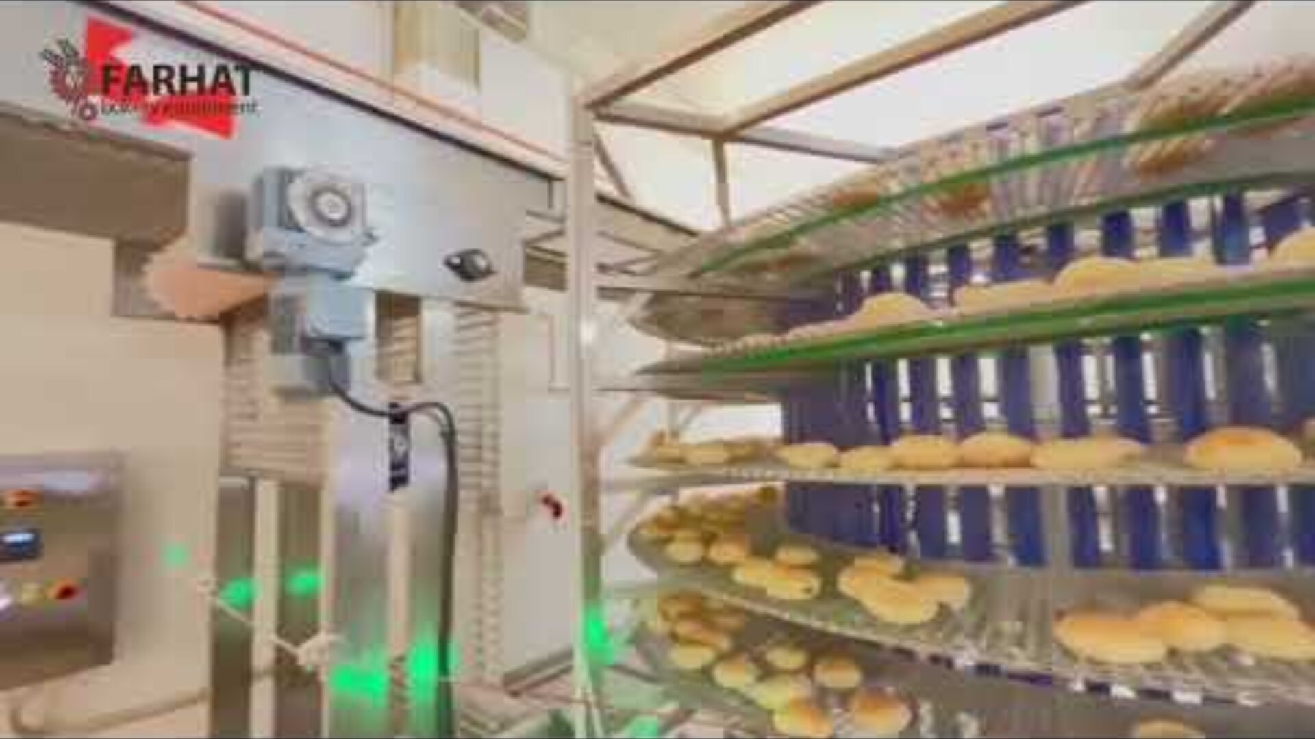 Circular racks filled with bread move on an industrial conveyor belt in a bakery. Machines and control panels can be seen, and the Farhat company logo appears in the upper left corner.