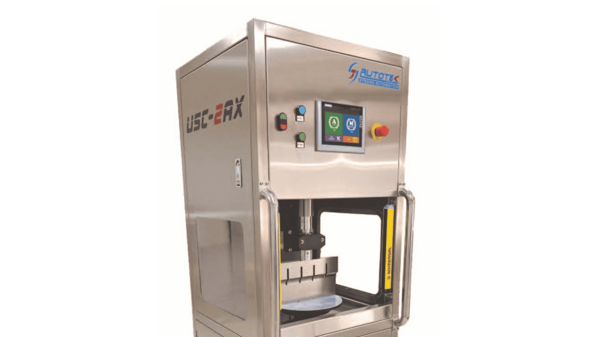 A stainless steel automatic machine with a digital touch screen, labeled “UBC-EMX,” designed for industrial or food processing use, with a plate positioned inside and safety bars on the sides.