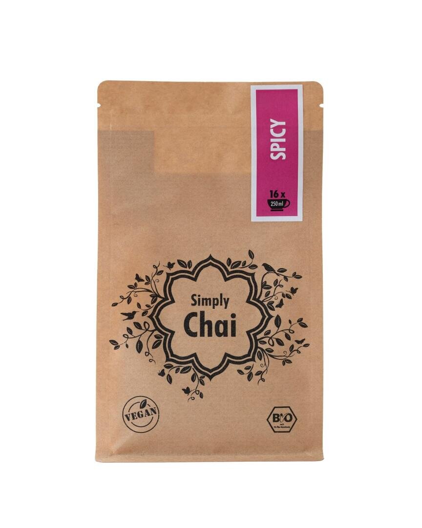 Eine braune Papierpackung mit der Aufschrift „Simply Chai“ mit Blumenmuster, Vegan- und Bio-Symbolen und einem violetten Etikett oben mit der Aufschrift „Spicy“ und der Angabe „16 x 250 ml“.