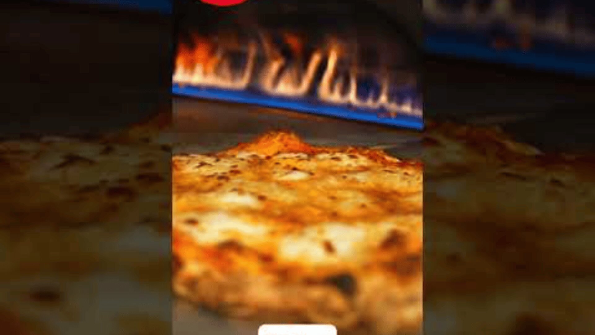 A close-up of a cheese pizza baking in a wood-fired oven, with flames visible in the background.