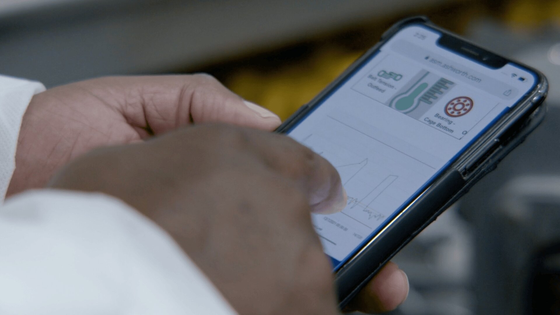 Eine Person verwendet ein Smartphone und durchsucht eine Website mit Diagrammen und Schaubildern zu Chemie oder Naturwissenschaften, wobei sie mit dem Finger auf den Bildschirm zeigt.