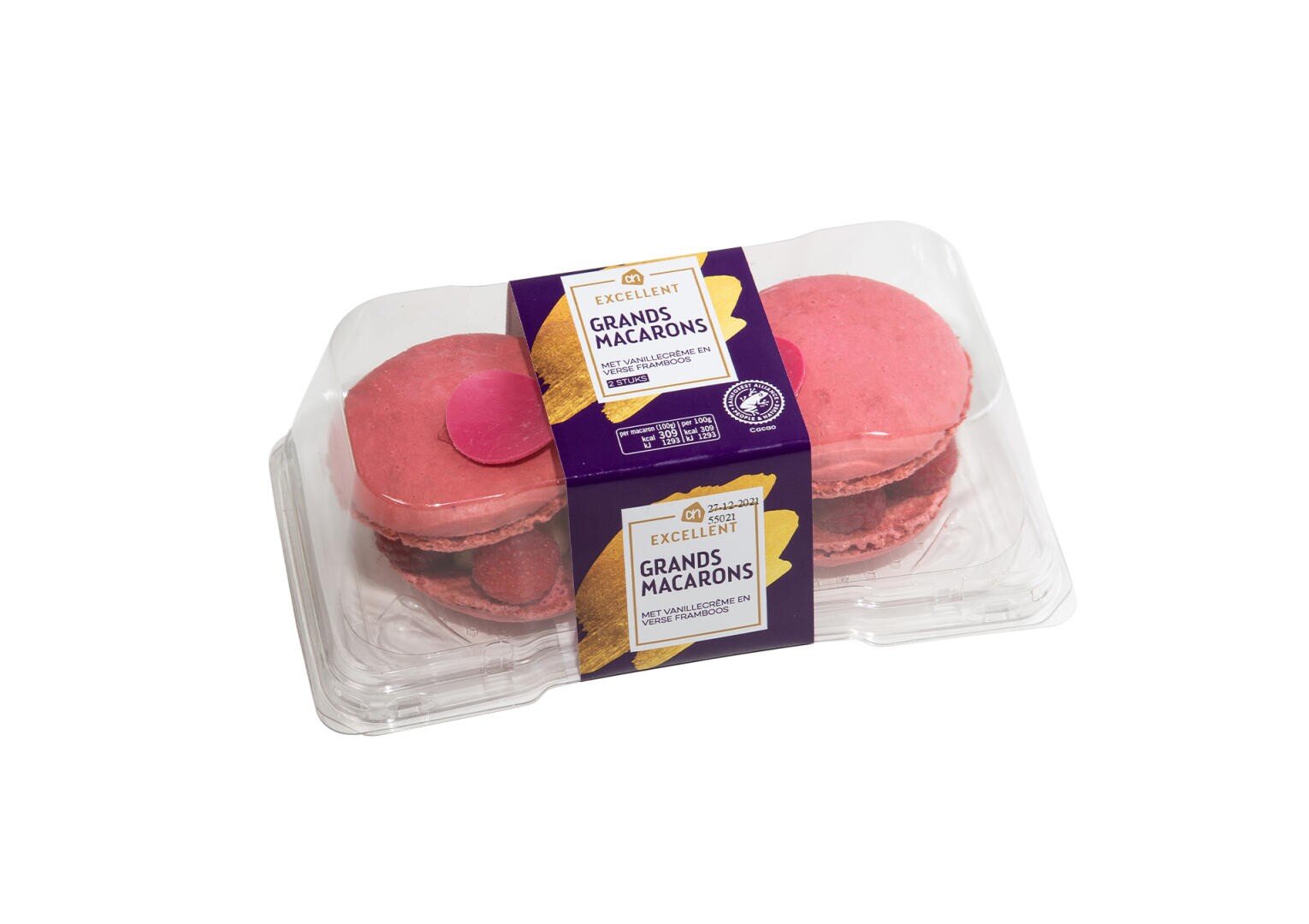 A clear plastic container holds two large pink macarons. The label reads Excellent Grands Macarons in French and English, with purple and gold accents. The packaging is placed on a white background.