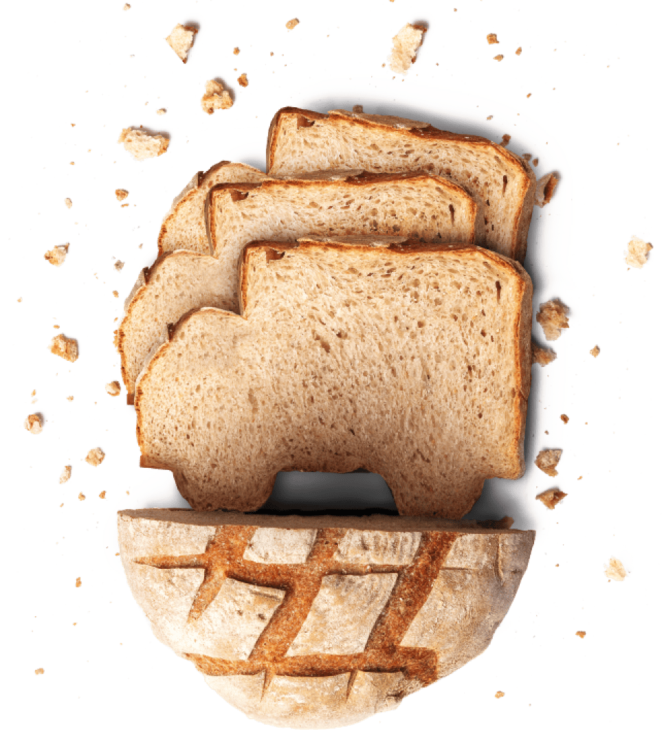 Auf einem runden Laib liegen drei Scheiben Vollkornbrot in Form eines Lastwagens, um die herum Brotkrümel verstreut sind, sodass es an einen Lastwagen auf einer Straße erinnert.