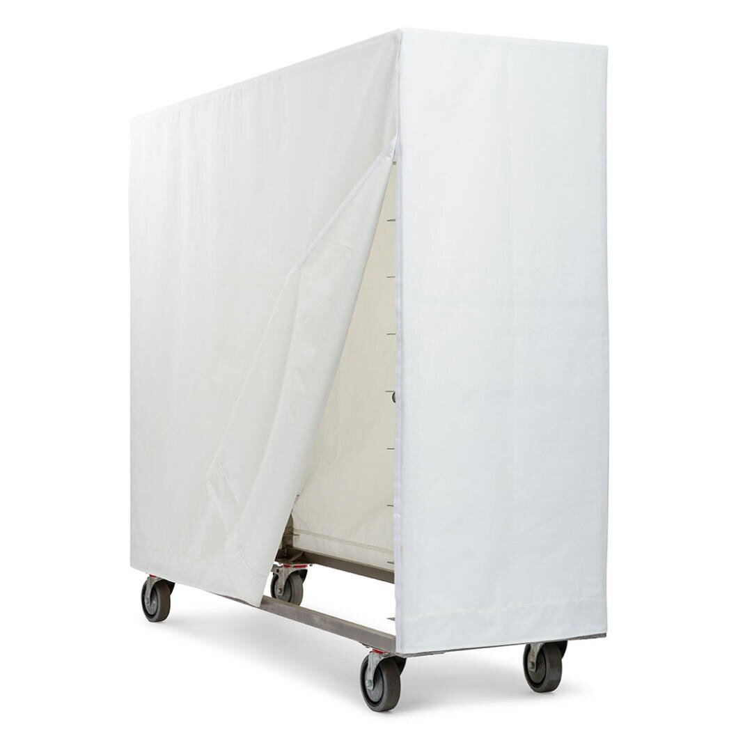 Ein großer Metallwagen auf Rädern, bedeckt mit einem weißen Stoffüberzug, der teilweise geöffnet wurde, um die Struktur des Wagens im Inneren zu enthüllen, vor einem schlichten weißen Hintergrund.