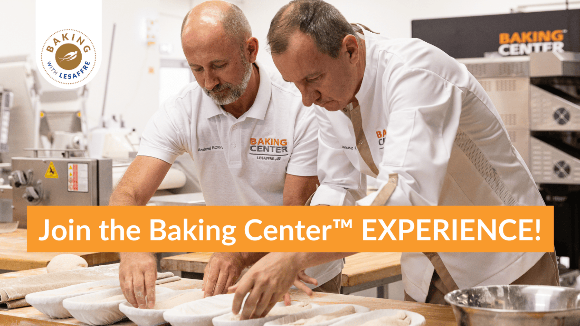 Two men in white chef uniforms shape dough in a professional bakery kitchen. An orange banner reads, “Join the Baking Center™ EXPERIENCE!” Various baking equipment and loaves of bread are visible in the background.