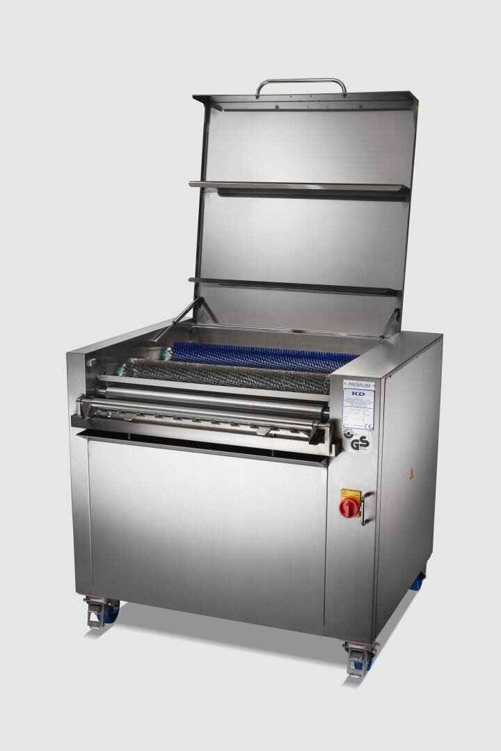 Eine große Industriemaschine aus rostfreiem Stahl mit offenem Deckel, blauem Förderband, Bedientasten und Rädern am Boden, die für die Lebensmittelverarbeitung oder Reinigungszwecke konzipiert ist.