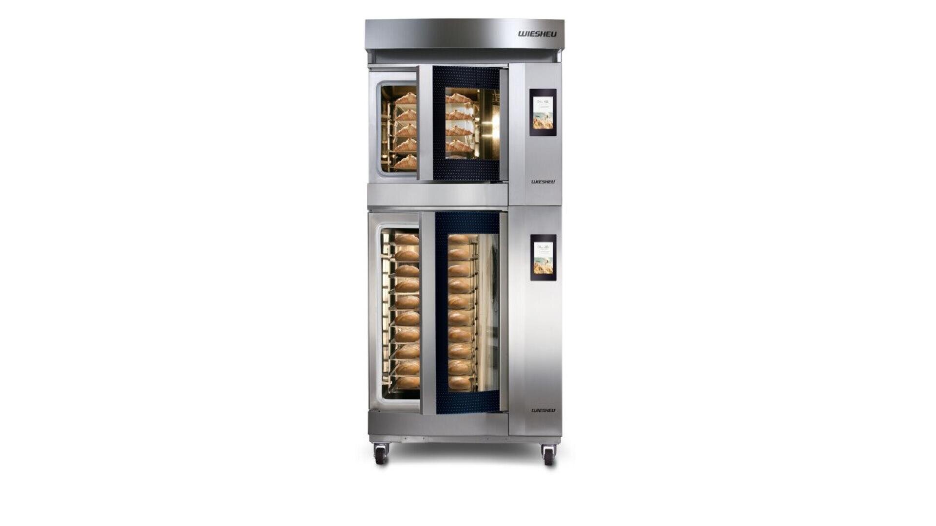 A large commercial oven with two stacked compartments, each with a glass door showing multiple trays of baked goods, digital control panels on the right, and a stainless steel exterior on wheels.