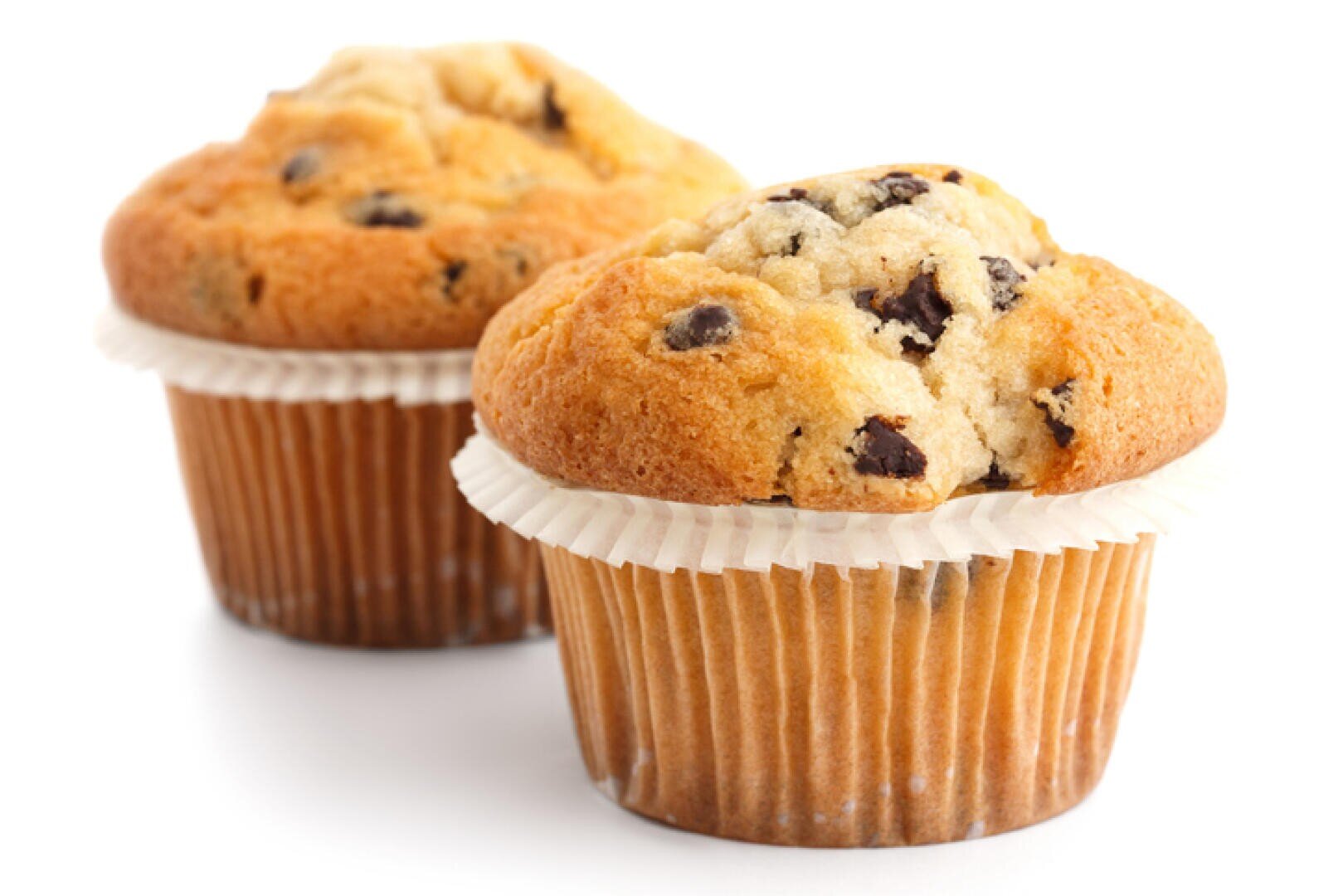 Two chocolate chip muffins in paper liners are placed on a white background. The muffins are golden brown with visible chocolate chips on top, and one is slightly behind the other.