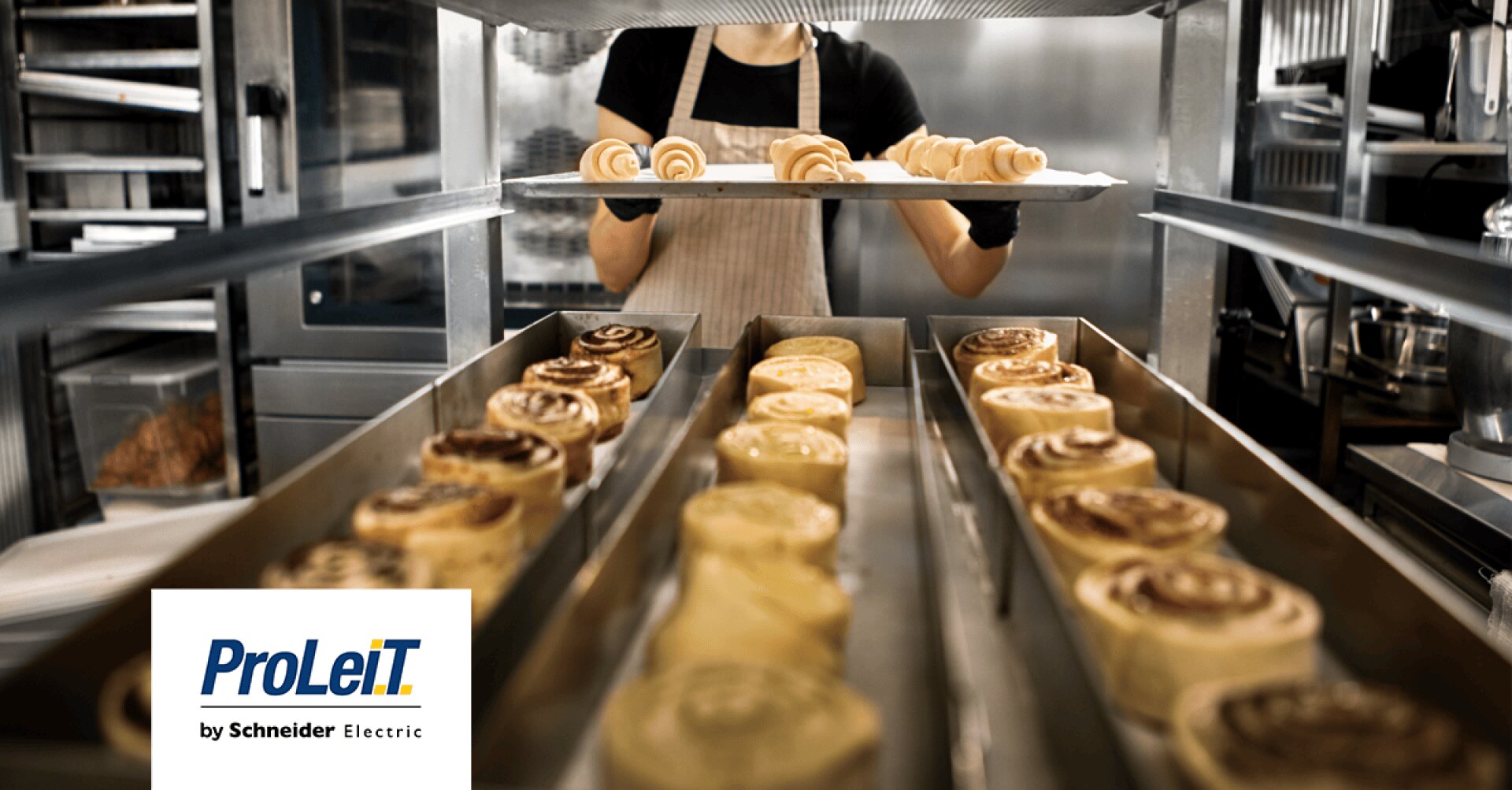 A baker places a tray of unbaked pastry rolls on a rack, with rows of baked cinnamon rolls cooling below. The ProLeiT by Schneider Electric logo appears in the lower left corner.