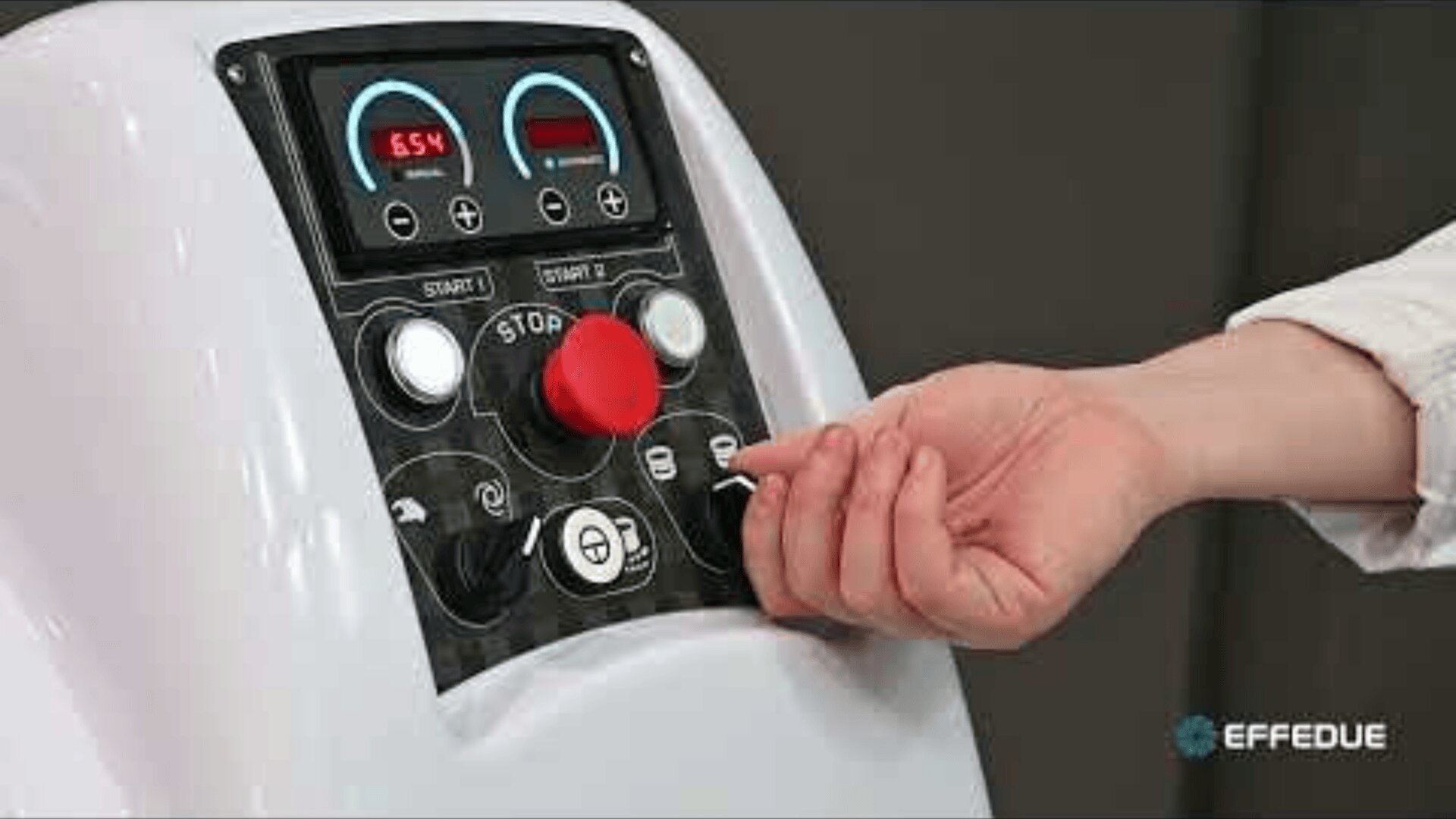 A person turns a switch on a control panel with a large red emergency stop button, various dials, and a digital display showing numbers. The panel is labeled with symbols and the Effedue logo.