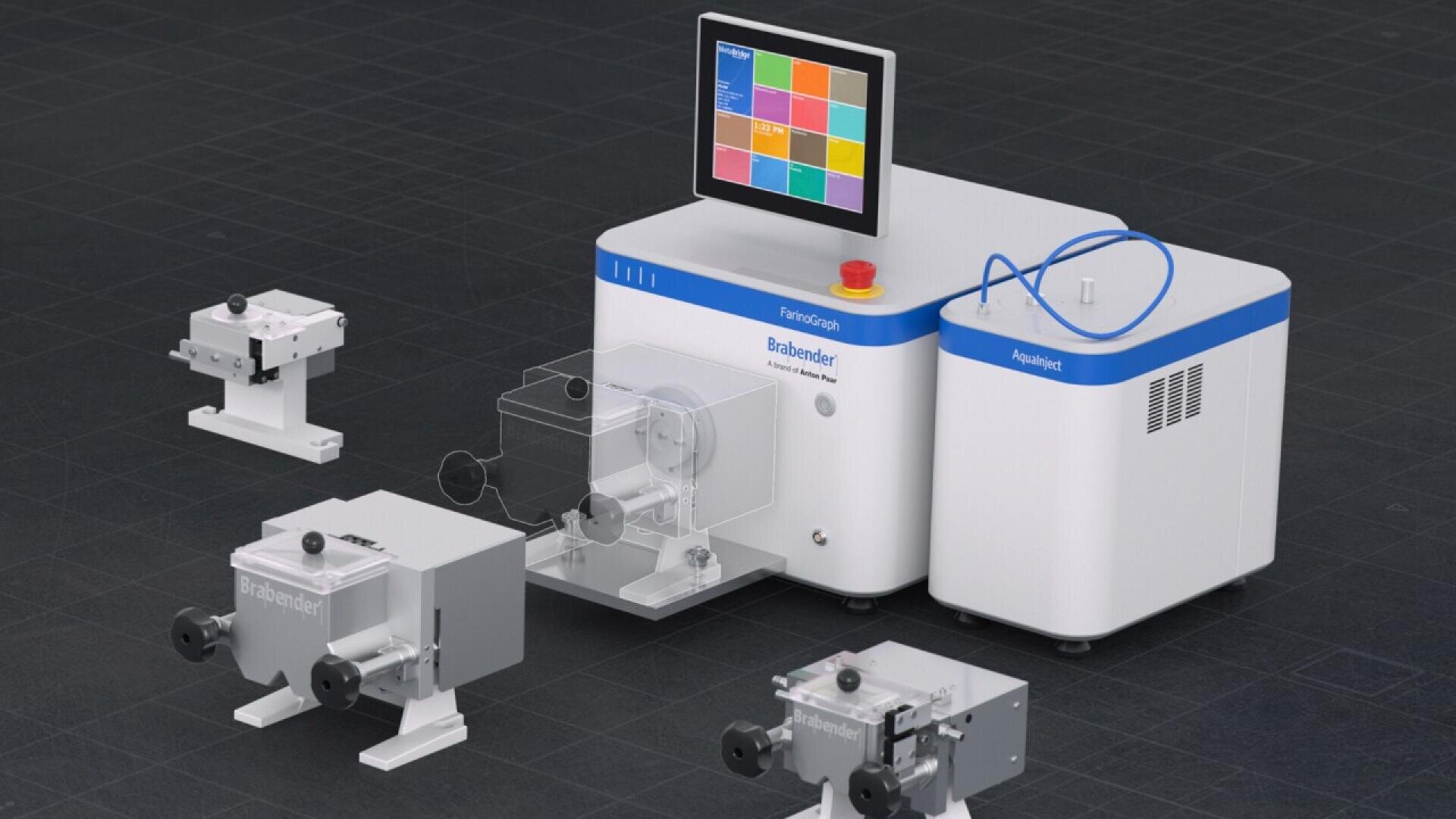 A laboratory instrument with a touchscreen display, labeled Functional Blender Chamber, is connected by tubing to a separate white unit on the right. Several small mechanical components are arranged nearby on a black surface.