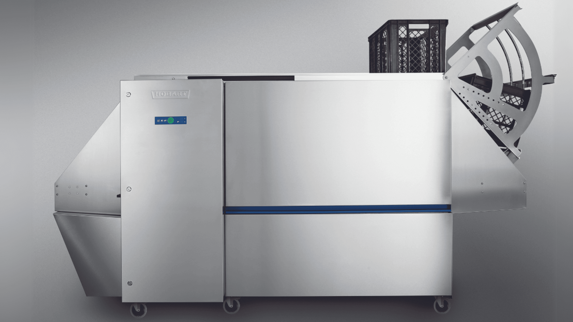 Eine große industrielle Spülmaschine mit einem Gehäuse aus rostfreiem Stahl, einem digitalen Bedienfeld und einem offenen Gestell mit Geschirr an einem Ende. Die Maschine ist vor einem schlichten, hellgrauen Hintergrund zu sehen.
