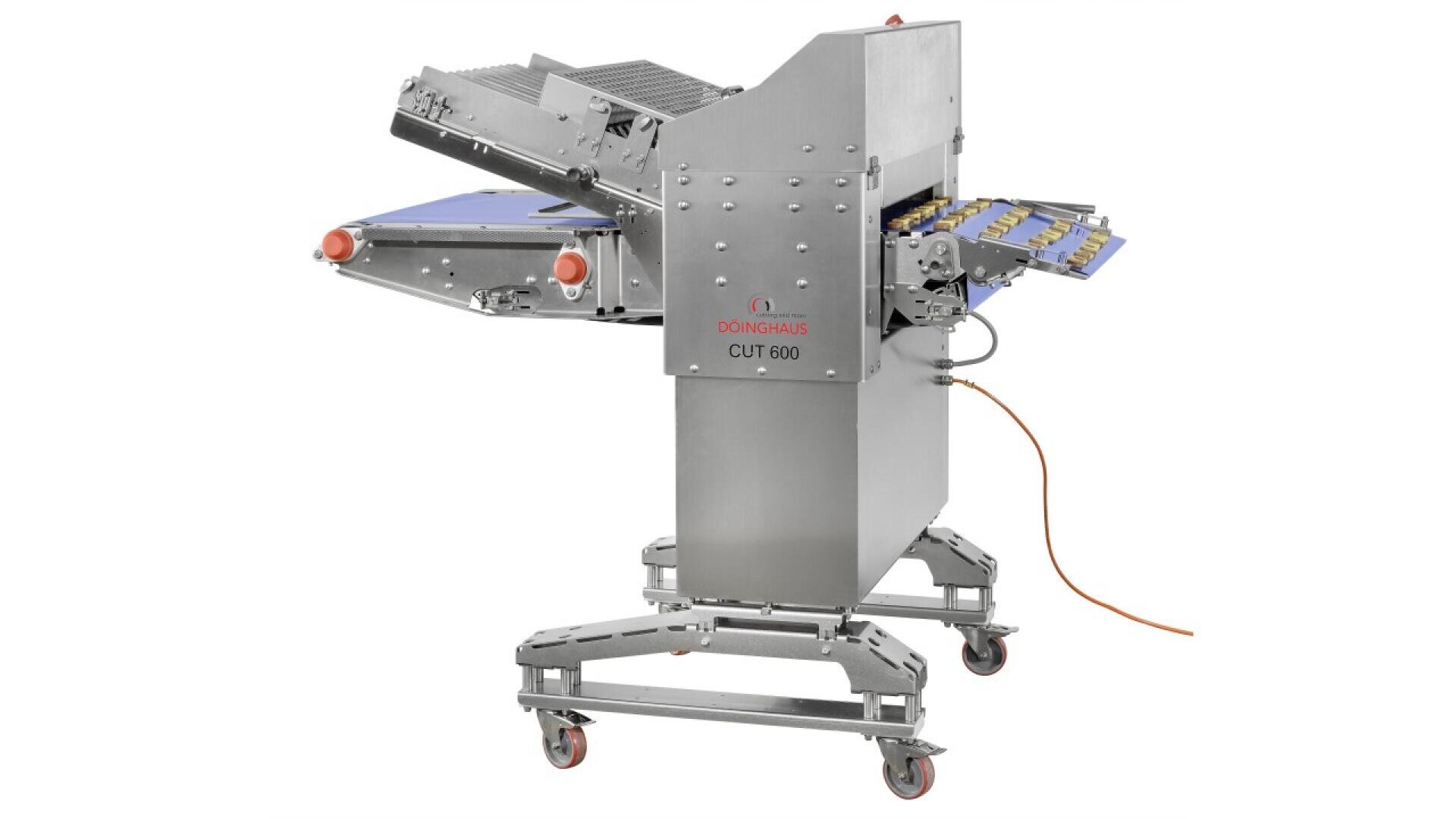 A stainless steel industrial food slicer machine with conveyor belts, labeled Donghai Cut 600, stands on wheels with an orange power cable attached.