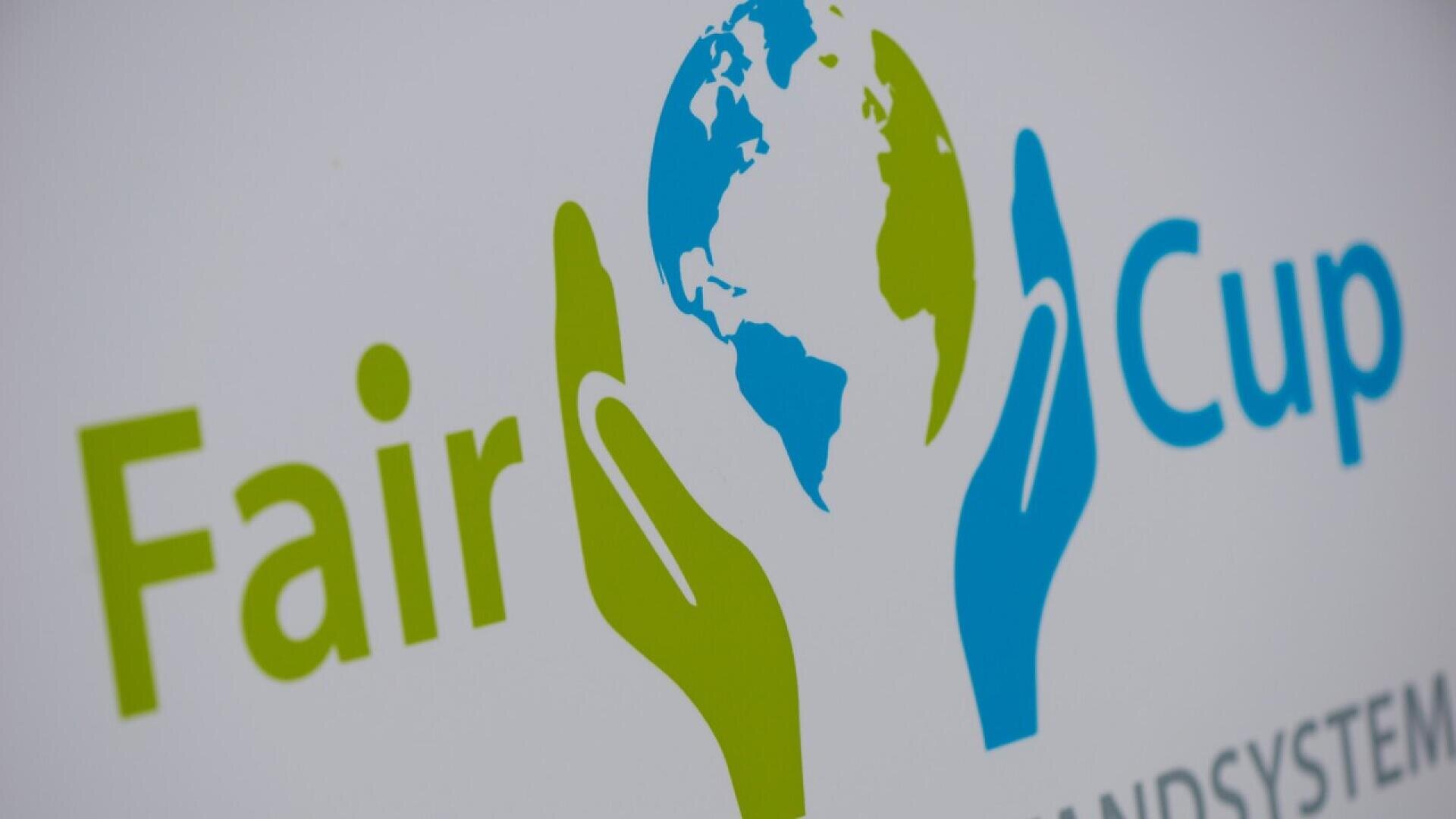 Logo with the words Fair Cup beside green and blue hands holding a globe, symbolizing sustainability and environmental care.