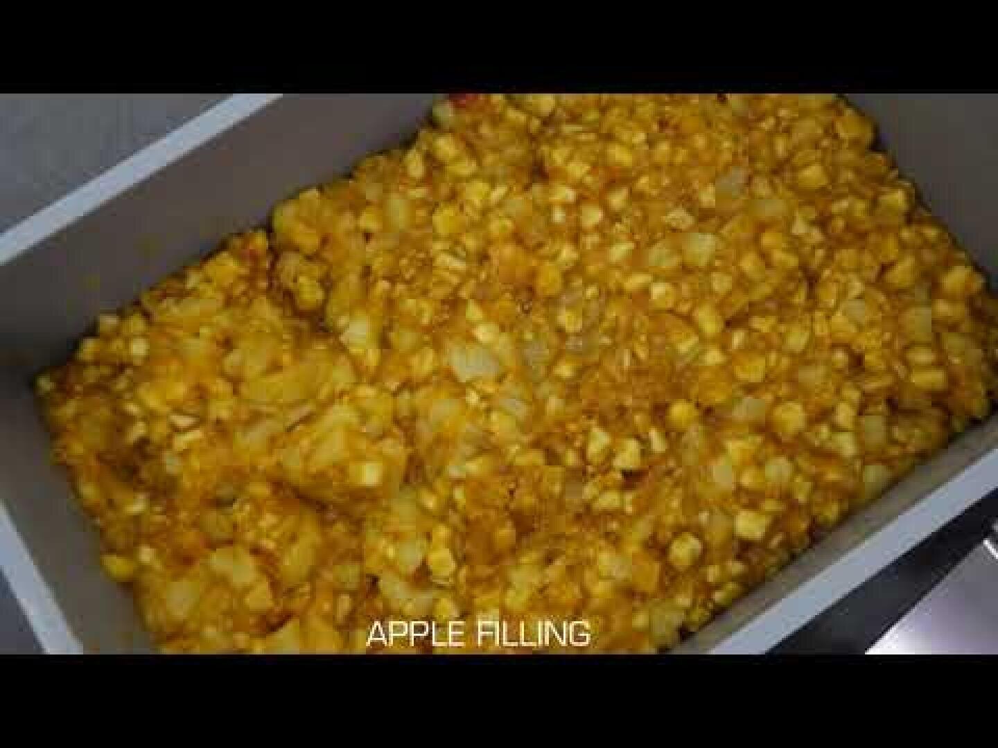 A rectangular baking dish filled with chunky apple filling, featuring diced apples mixed with spices. The text APPLE FILLING appears at the bottom of the image.