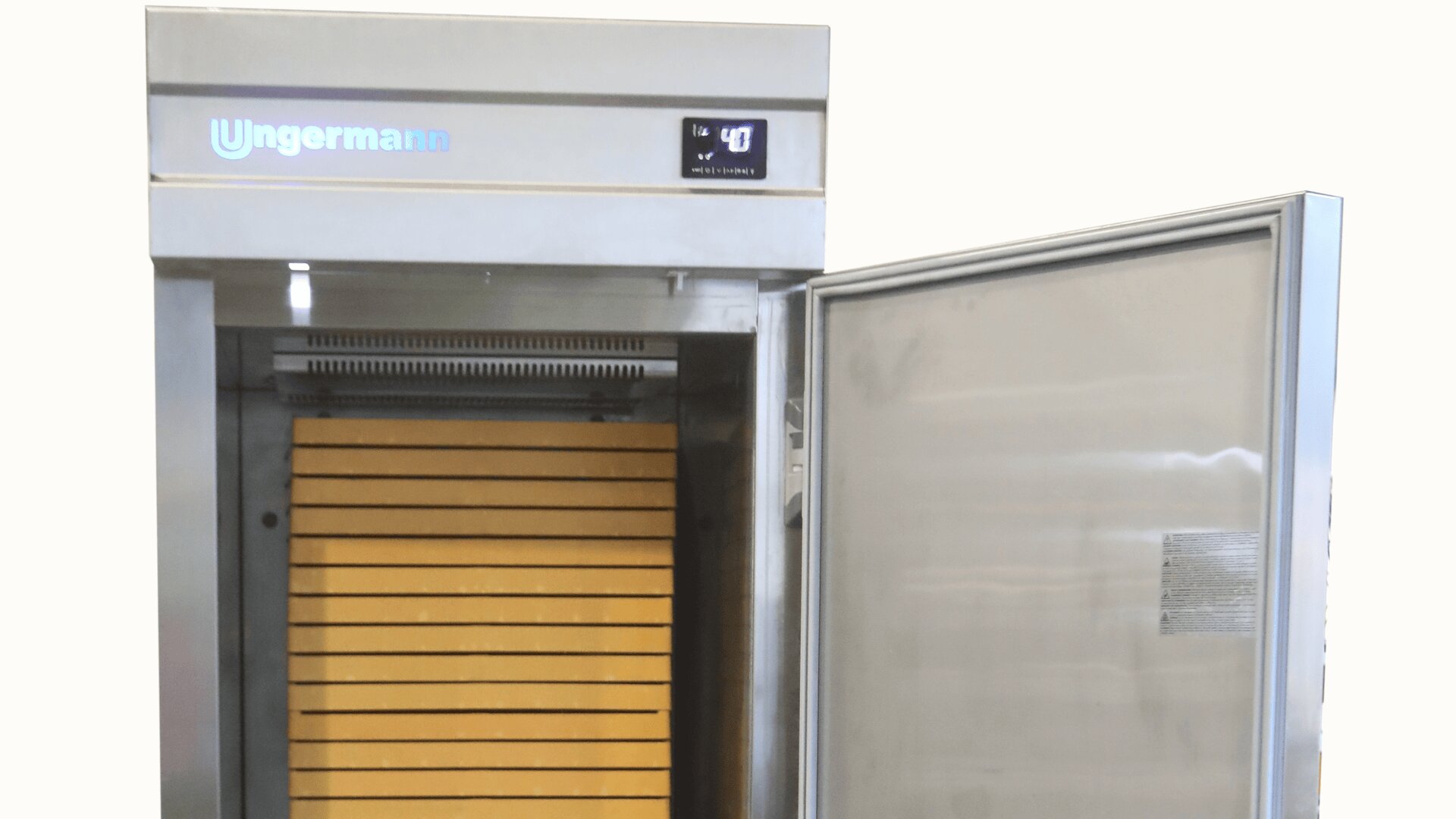 Ein großer Industriekühlschrank aus Edelstahl mit geöffneter Tür, die mehrere Holzablagen im Inneren offenbart. Die digitale Anzeige auf der Oberseite zeigt die Temperatur von 4°C an. Der Markenname Ungermann ist sichtbar.