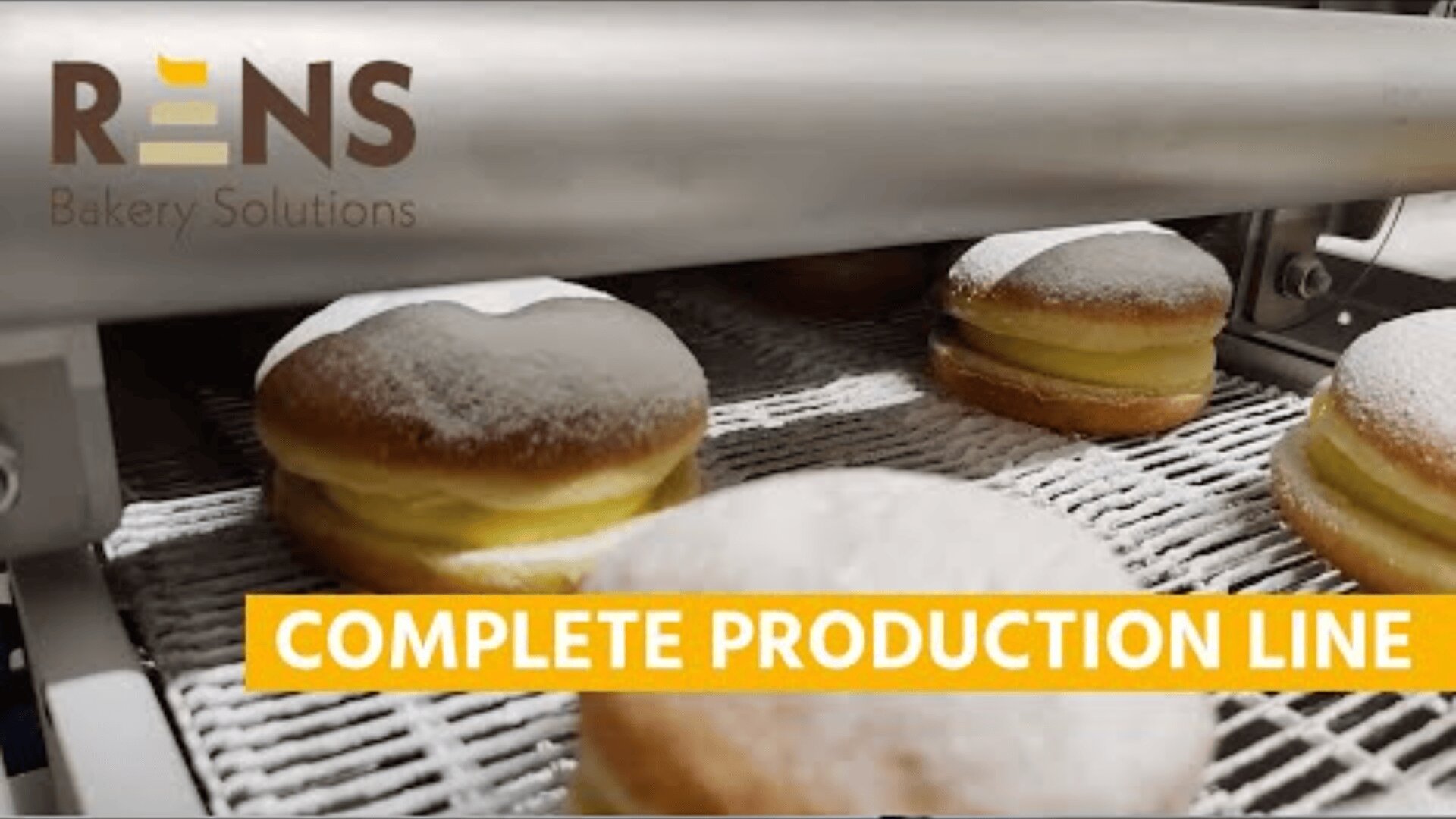 Powdered donuts move along a conveyor belt in a bakery production line. The text RENS Bakery Solutions and COMPLETE PRODUCTION LINE appears on the image.