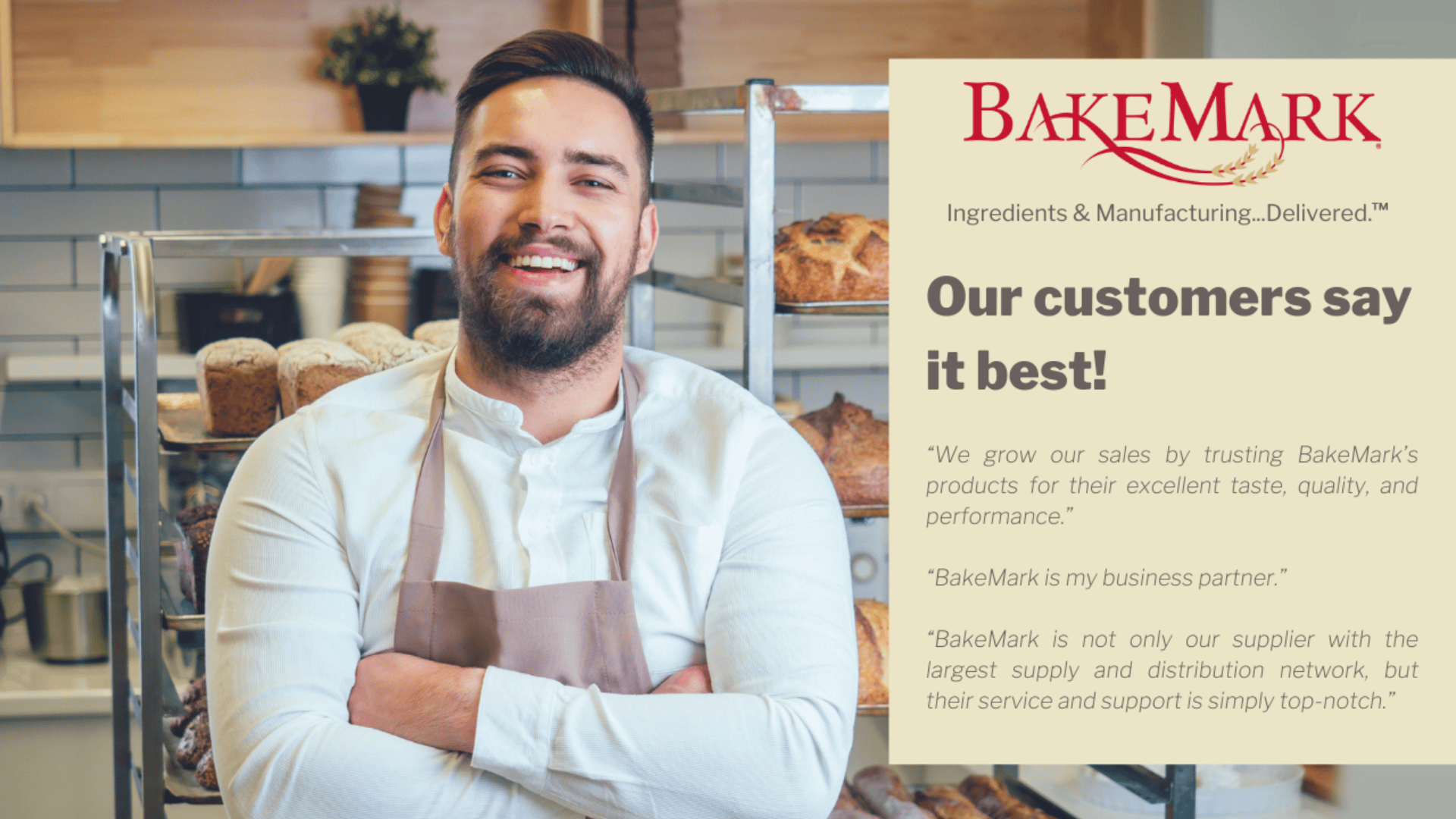 A smiling man with a beard and apron stands in a bakery kitchen. Next to him is a BakeMark sign with customer testimonials praising the brands products, service, and distribution network.