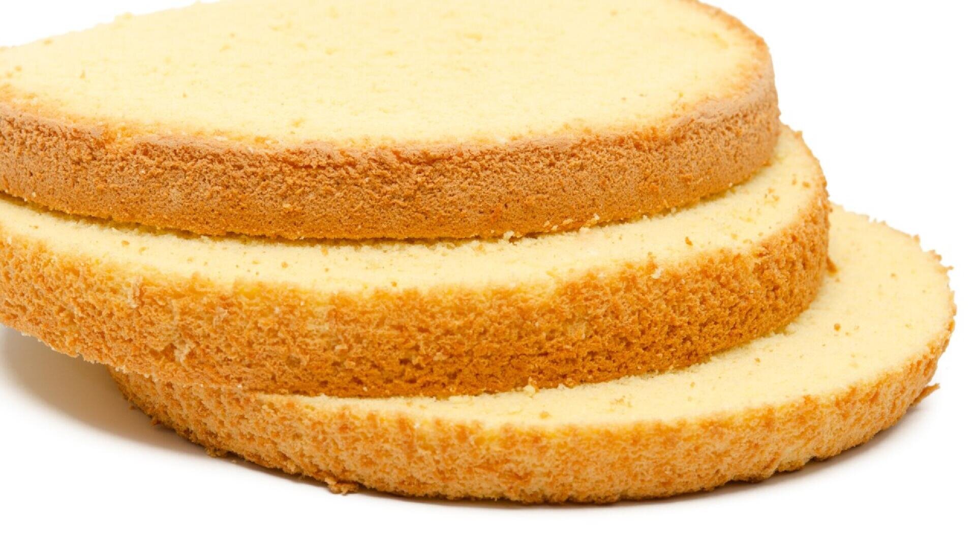 Three slices of plain sponge cake with golden-brown edges are stacked on top of each other against a white background.