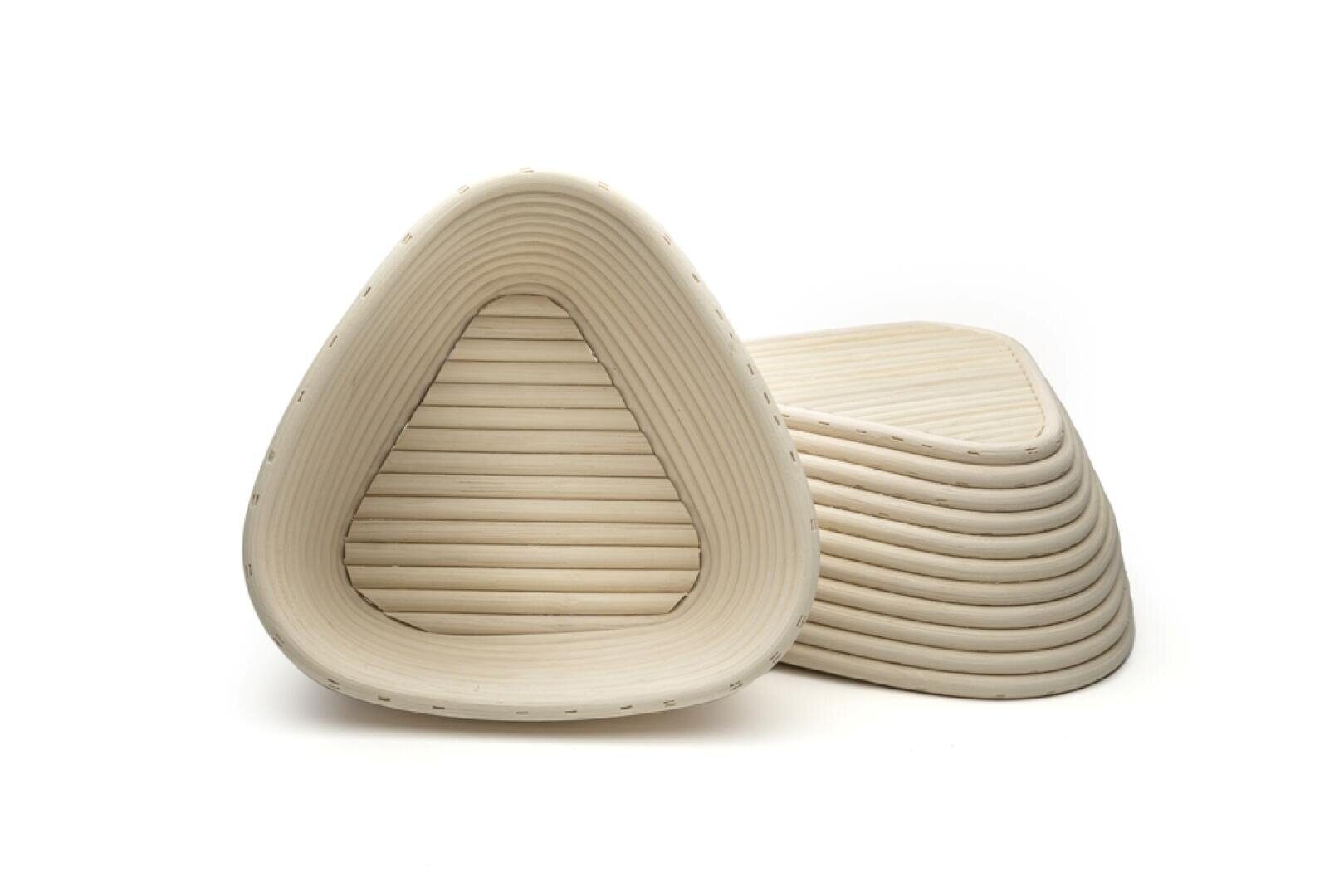 Ein Stapel dreieckiger, gerippter, heller Gärkörbe, wobei ein Korb aufrecht steht, um die innere Textur und Form zu zeigen.