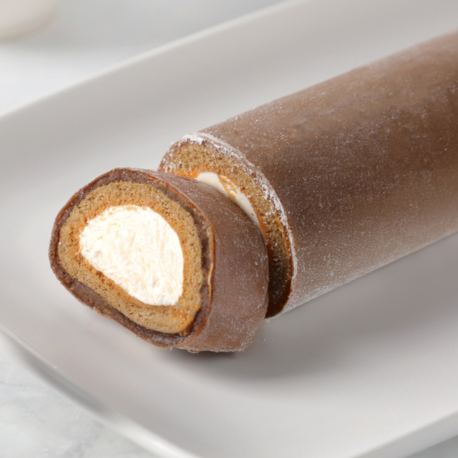 On a white plate is a chocolate sponge roll with a creamy white filling, with one piece cut to show the swirling layers of cake and filling.