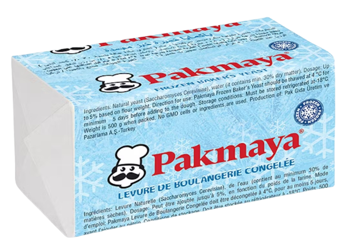 A blue and white package of Pakmaya frozen baker’s yeast with a cartoon chef logo, product information, and ingredients listed in French and English on the wrapping.